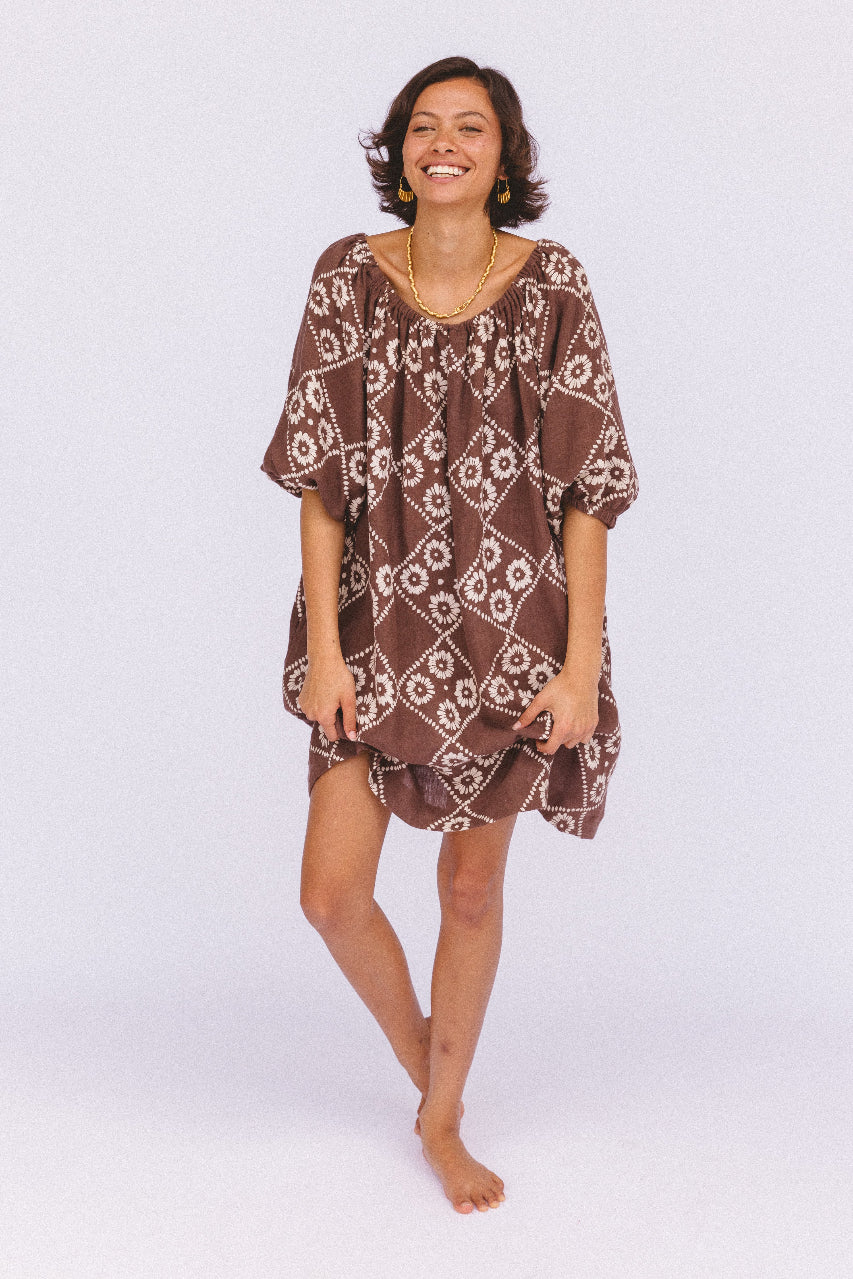 Dahlia Mini Dress Maple — smiling studio model full length, loose boho silhouette, hand block print linen mini in maple brown, diamond daisy geometric print, artisan made slow fashion | Daughters of India