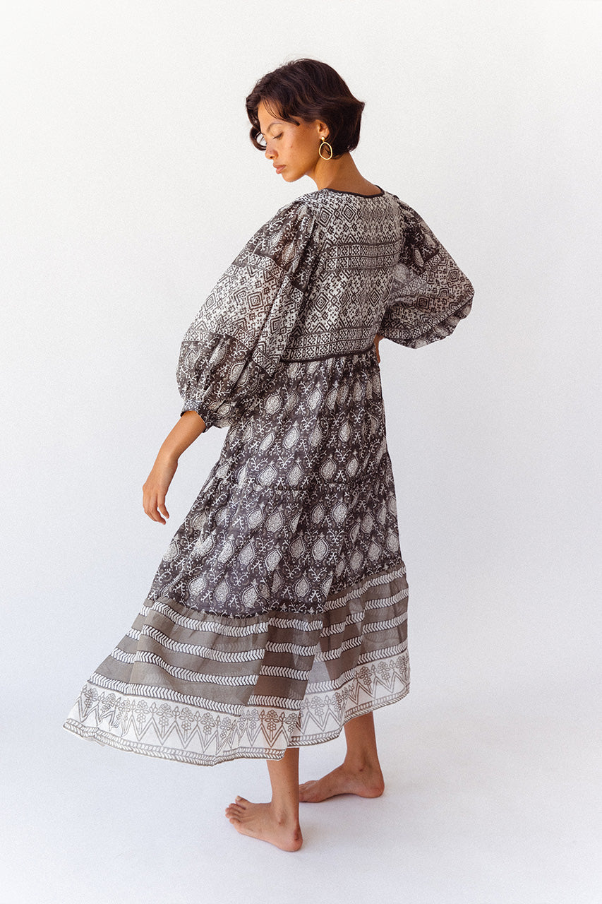 Daughters of India Jasmine Midi Dress in Charcoal — studio back view walking, tiered border hem and balloon sleeves