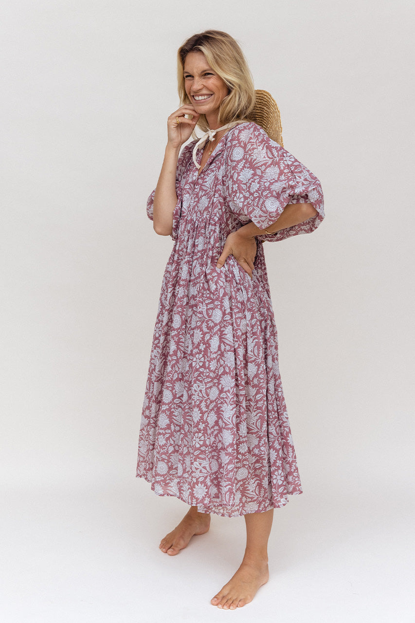 Daughters of India Kyra Midi Dress in Musk — studio full length smiling with straw hat, hand in pocket, flowing skirt