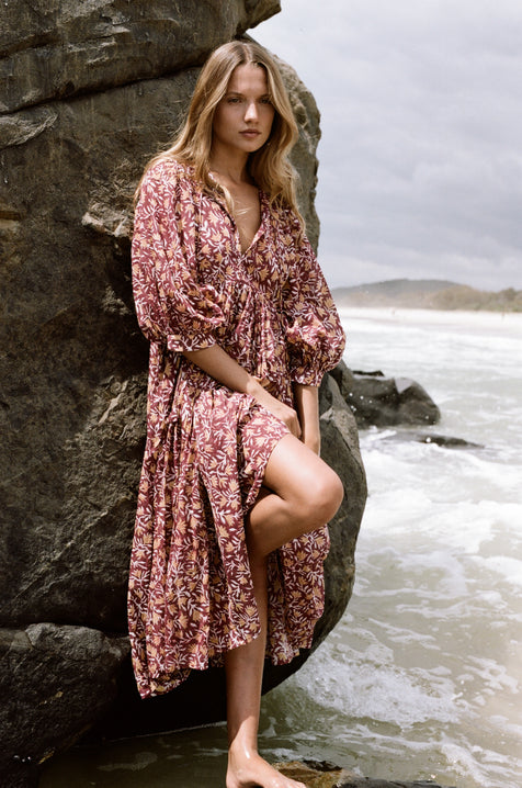 Daughters of India Kyra Midi Dress in Sumac — leaning on rock by ocean, hand screen print cotton
