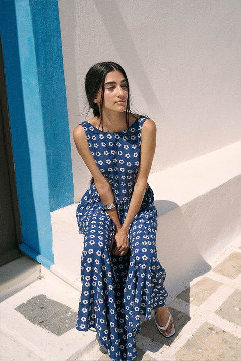 Veda Dress Indigo — front three-quarter view by turquoise wall, model wearing indigo hand block print linen blend midi dress with botanical motif, relaxed fit, artisan Jaipur India | Daughters of India