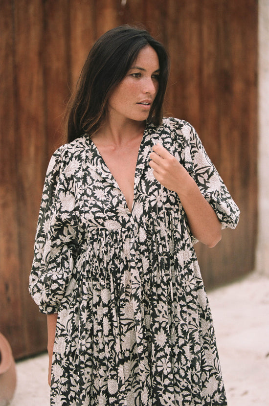 Daughters of India Kyra Maxi Dress in Pepper — close-up V-neckline by wooden door, hand screen print floral detail