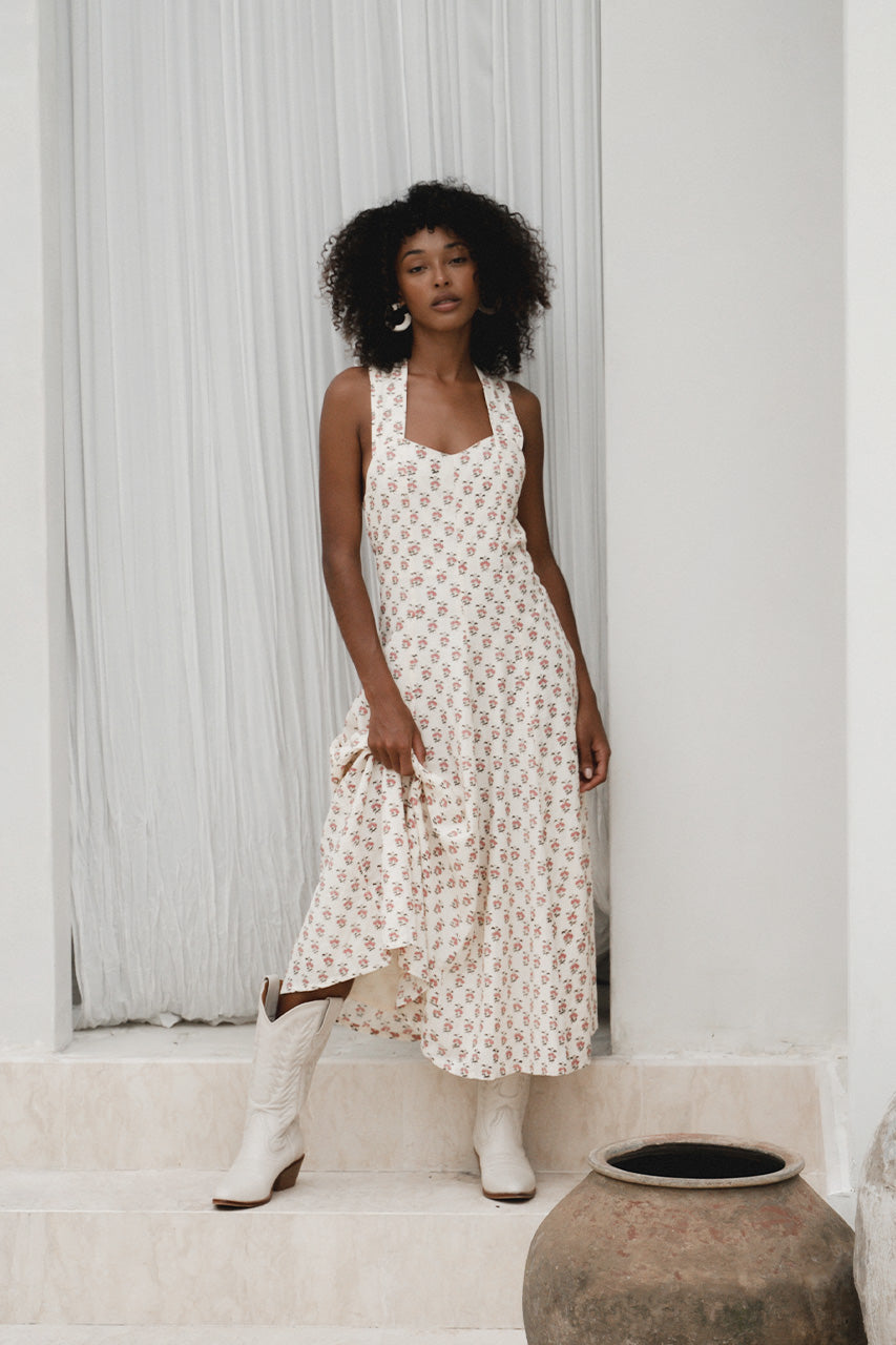 Lalika Dress Peony — back view by villa pool, peony hand block print cotton wrap dress showing cross-back strap detail and A-line silhouette, cream with pink floral motifs | Daughters of India